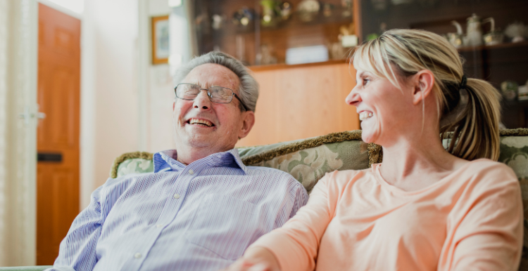 A carer talking to an elderly gentleman, they are both laughing