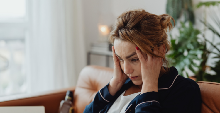 Lady sitting on a chair, with her hands on her head looking frustrated