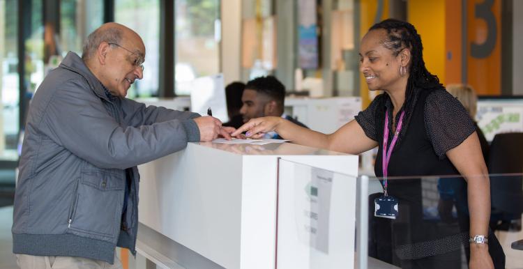 Male patient speaking to a receptionist