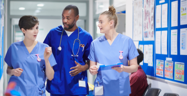 Image of nurses and a doctor talking in a hospital waiting room