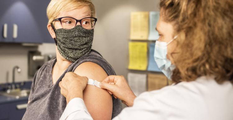 Women just after having COVId-19 jab having plaster stuck on arm 