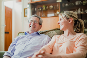 A carer talking to an elderly gentleman, they are both laughing