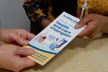 Hands holding Healthwatch leaflet