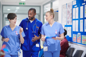 Image of nurses and a doctor talking in a hospital waiting room