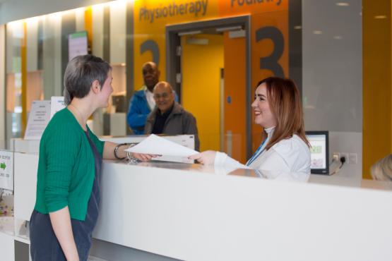 Woman speaking to someone at the hospital reception